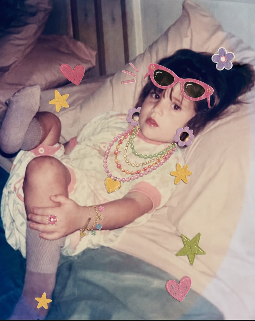 Niña jugando con collares y accesorios de su mamá, rodeada de corazones y estrellas